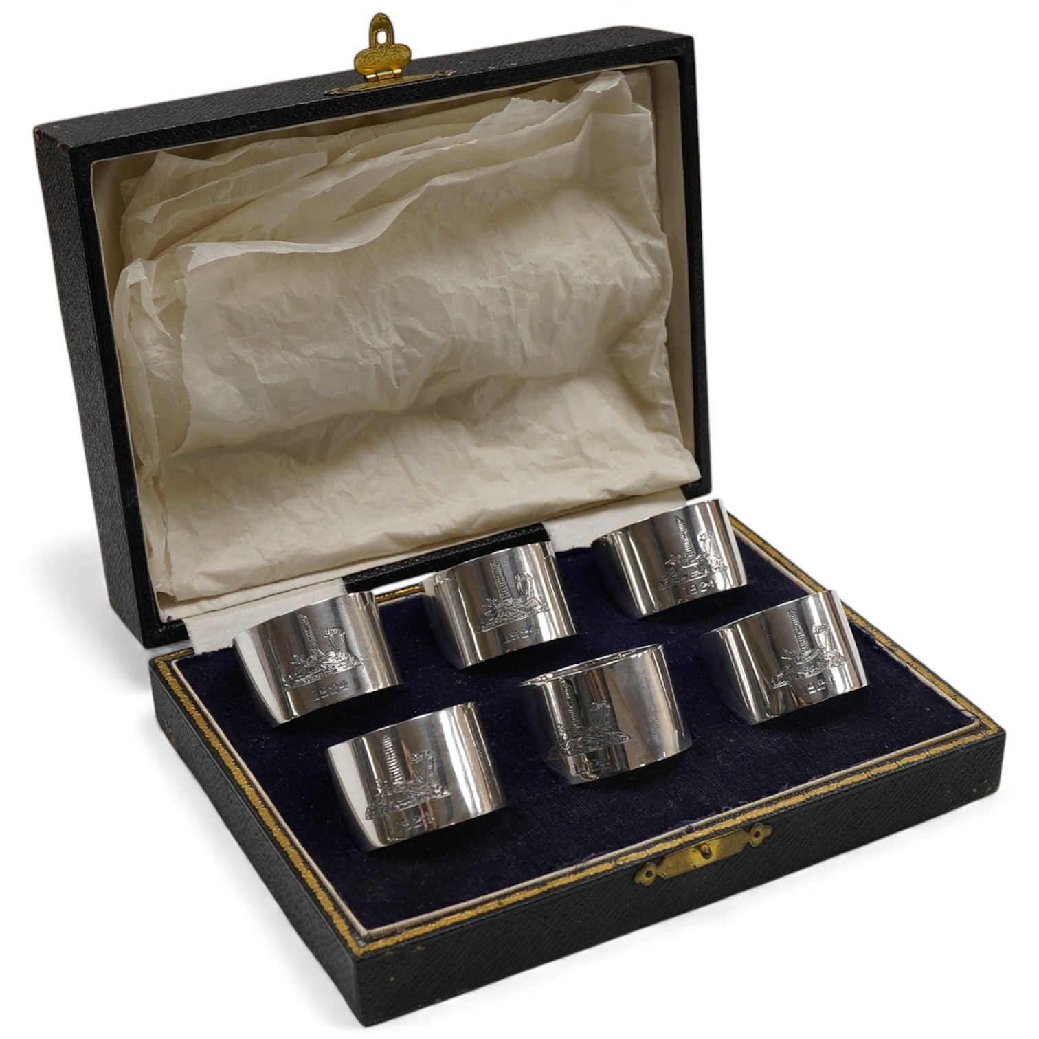 A cased set of six George V Irish silver napkin ring's, each engraved with a dear and harp on a rocky mound with tower and dated 1924, Wakely & Wheeler, Dublin, 1923.